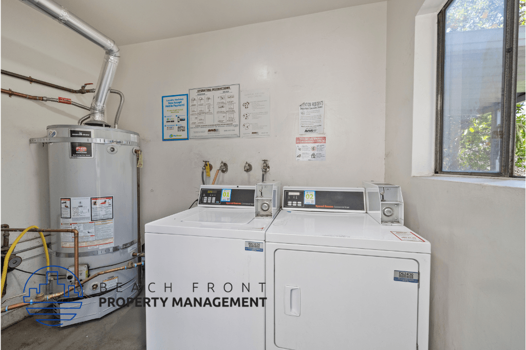 a laundry room with two washes and a water heater and a window