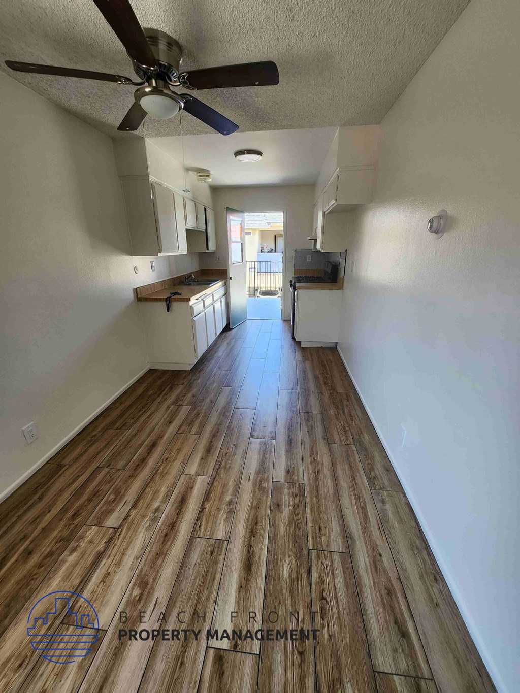A room with wooden flooring and a ceiling fan.