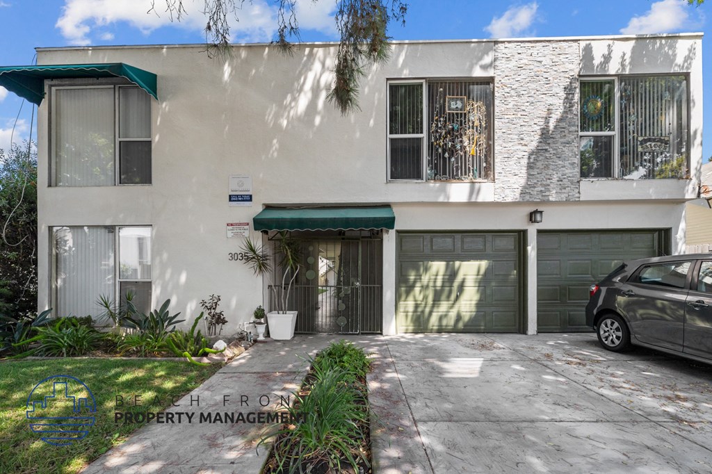 a white house with a garage and a car parked in front of it