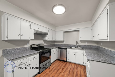 A kitchen with white cabinets and a granite countertop.