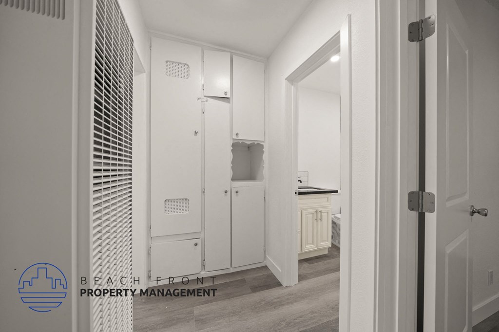 A hallway with a logo for Beach Front Property Management in the bottom left corner.