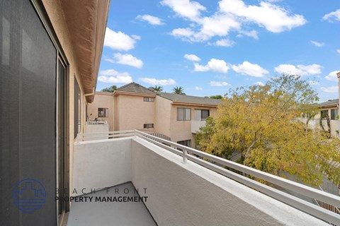 a balcony with a view of a building and a tree