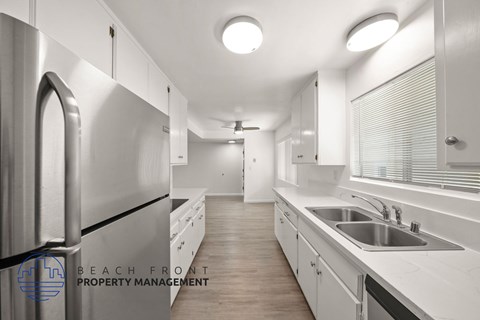 A modern kitchen with white cabinets and stainless steel appliances.