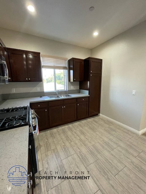 A kitchen with a stove top oven and cabinets.