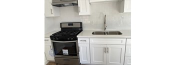 A modern kitchen with a stove and sink.