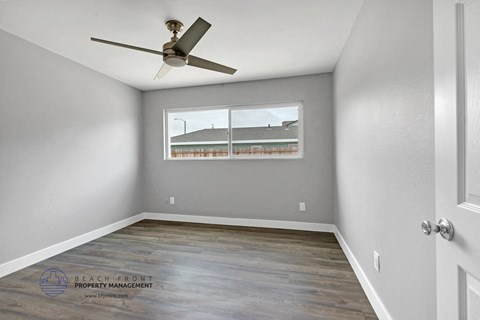 an empty room with a ceiling fan and a window