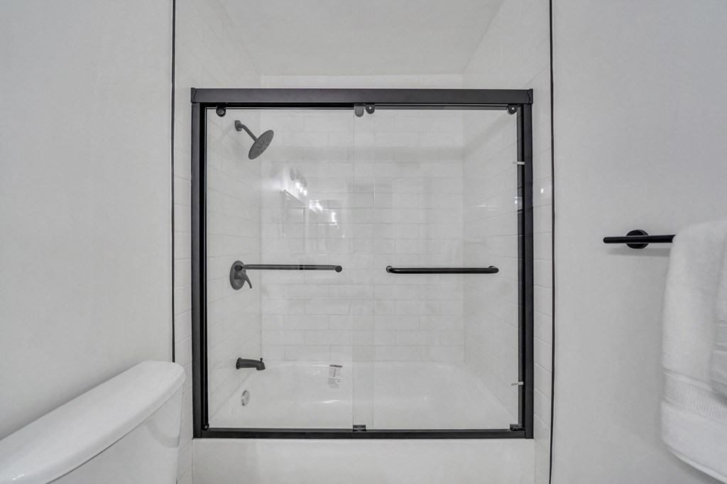 a white bathroom with a shower with a glass door