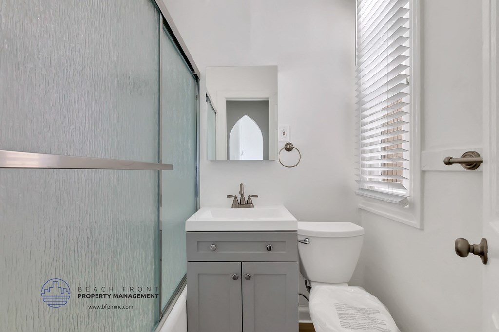 a white bathroom with a sink toilet and a shower