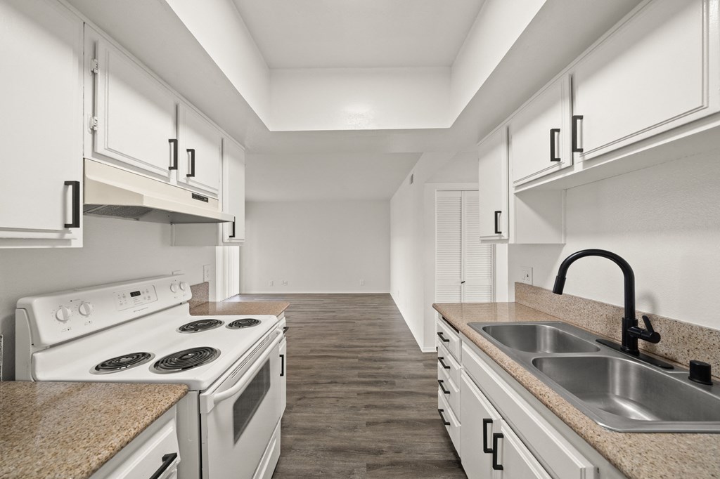 a kitchen with white cabinets and white appliances and a sink