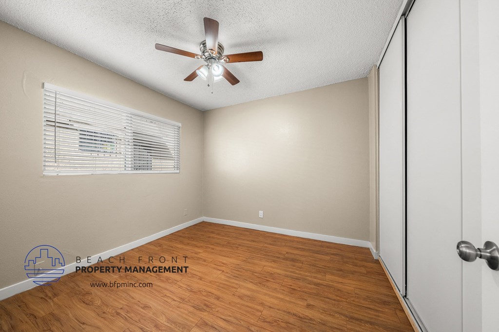 the living room has a hardwood floor and a ceiling fan