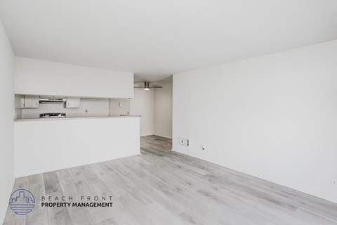 A spacious room with a logo for Beach Front Property Management in the bottom left corner.