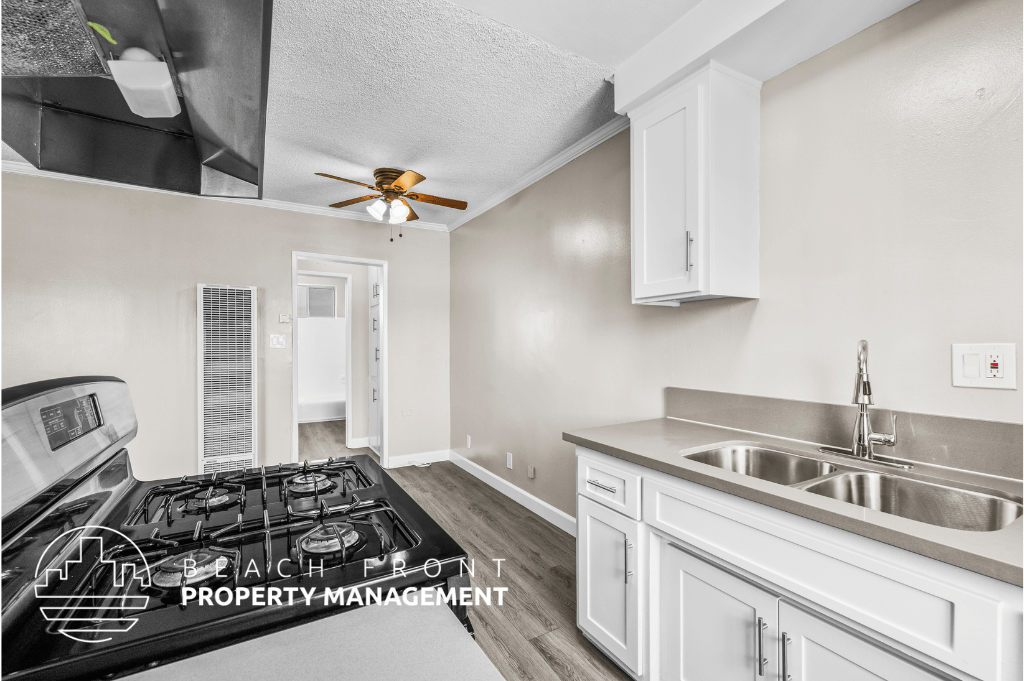 a kitchen with white cabinets and a stove and a sink