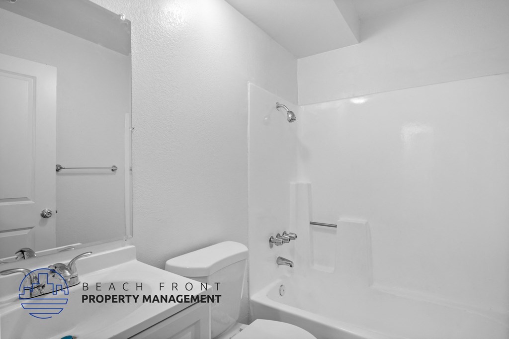 a white bathroom with a tub and a toilet and a sink
