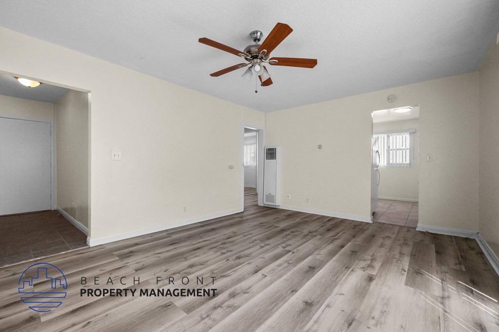 the living room and dining room with hardwood floors and a ceiling fan