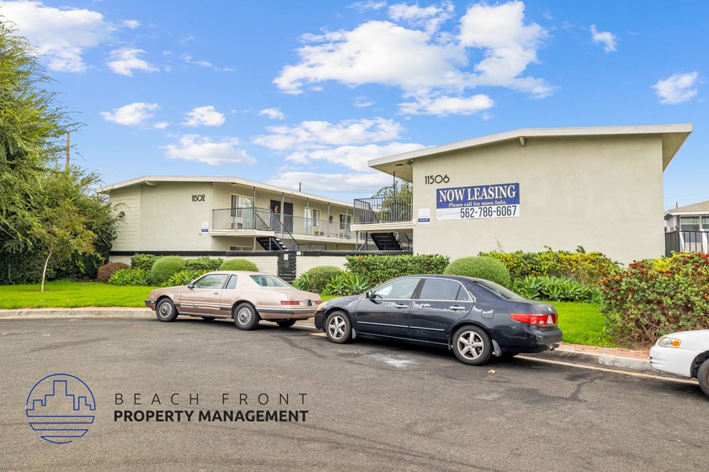 a beach front property management office with cars parked in front of it