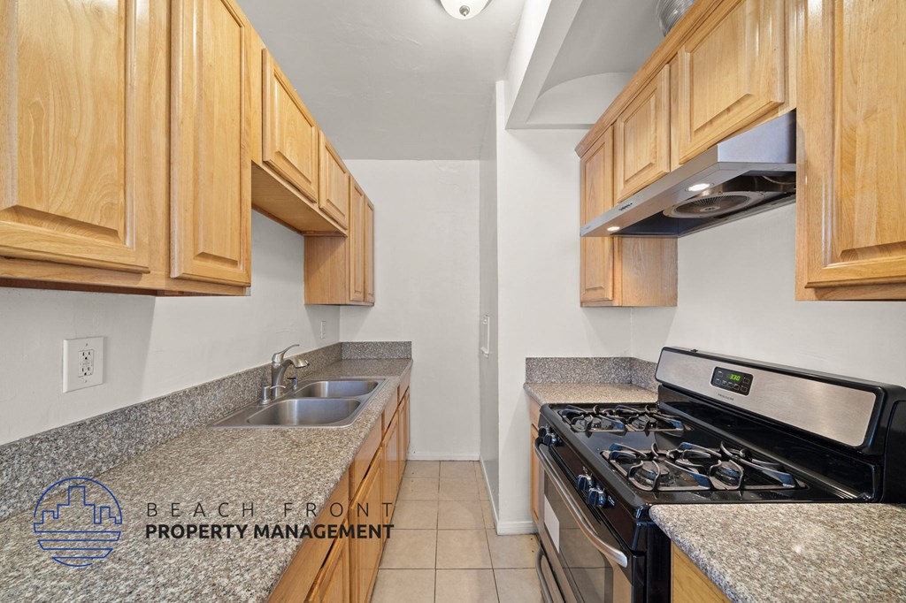 A kitchen with wooden cabinets and a granite countertop.