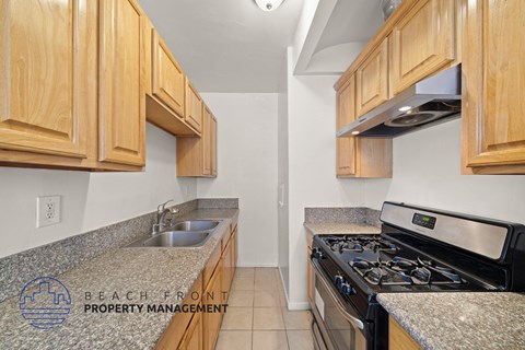 A kitchen with wooden cabinets and a granite countertop.
