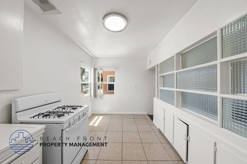 A kitchen with a stove and a logo for Beach Front Property Management.
