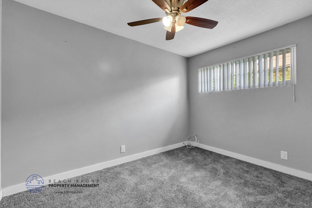 a bedroom with gray walls and a ceiling fan