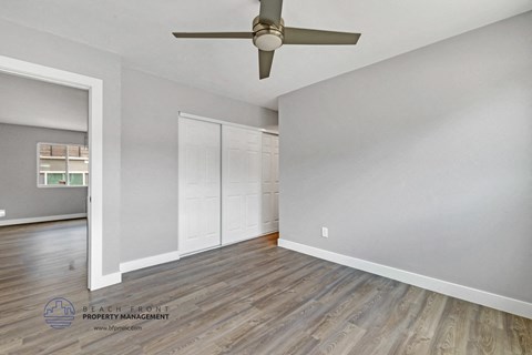 the living room of an empty house with a ceiling fan