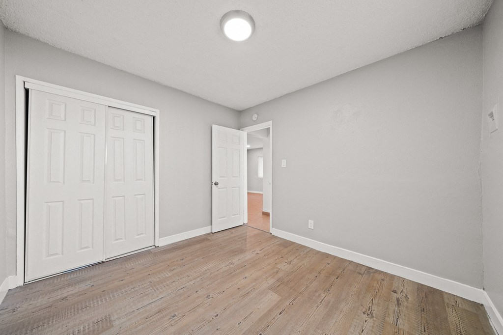 an empty living room with white walls and wood flooring