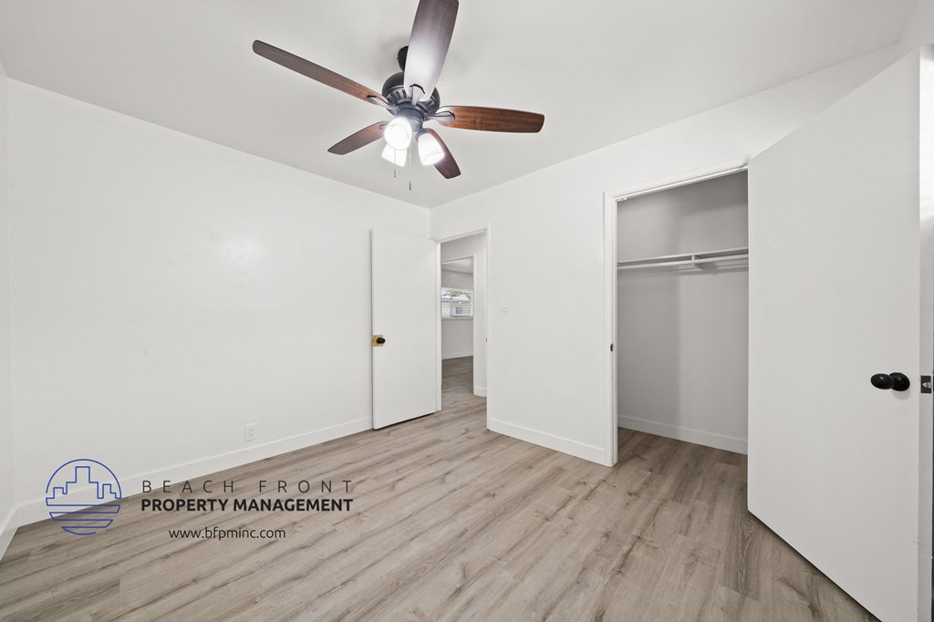 a bedroom with hardwood flooring and a ceiling fan