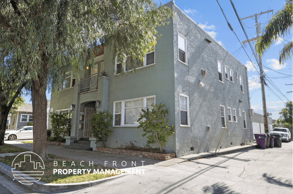 a grey building with a tree in front of it