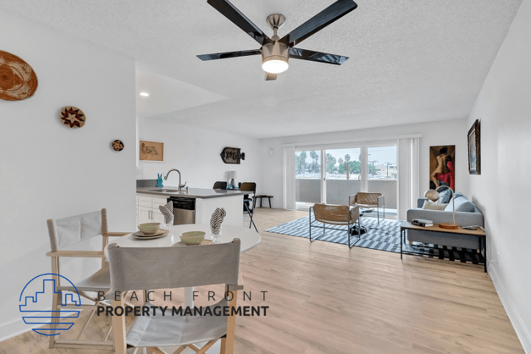 a living room with a ceiling fan and a table and chairs