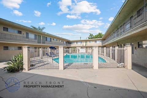 a swimming pool is behind a fence in an apartment building