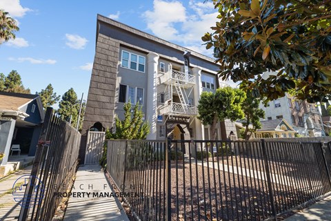 an apartment building with a gate and a fence in front of it