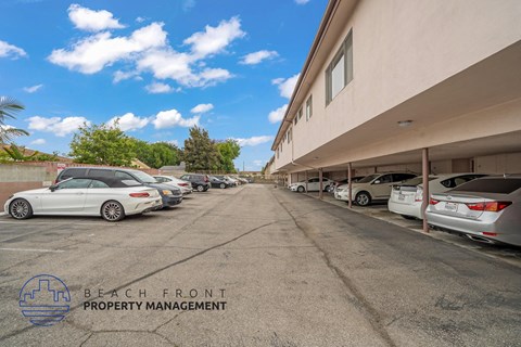 A parking lot with cars and a building in the background.