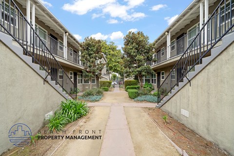 A row of apartment buildings with a walkway between them.