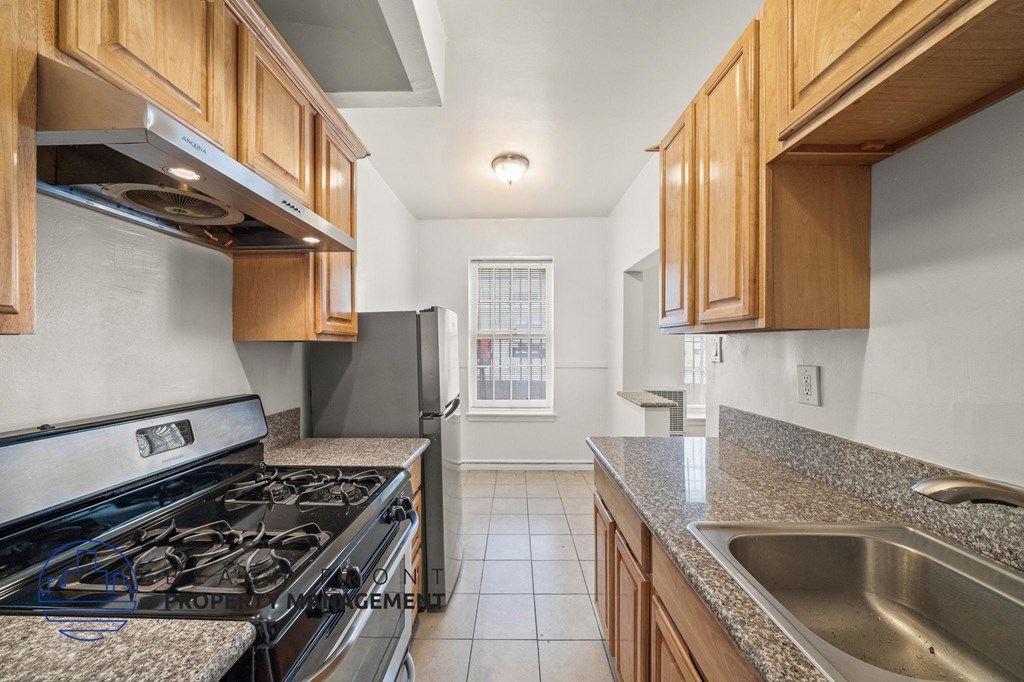 A kitchen with a stove top oven and a refrigerator.