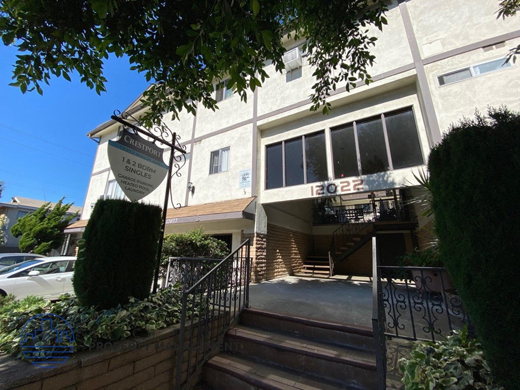the front of a building with stairs and a sign