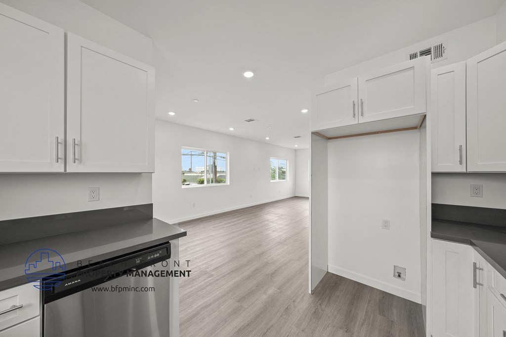 a white kitchen with white cabinets and stainless steel appliances