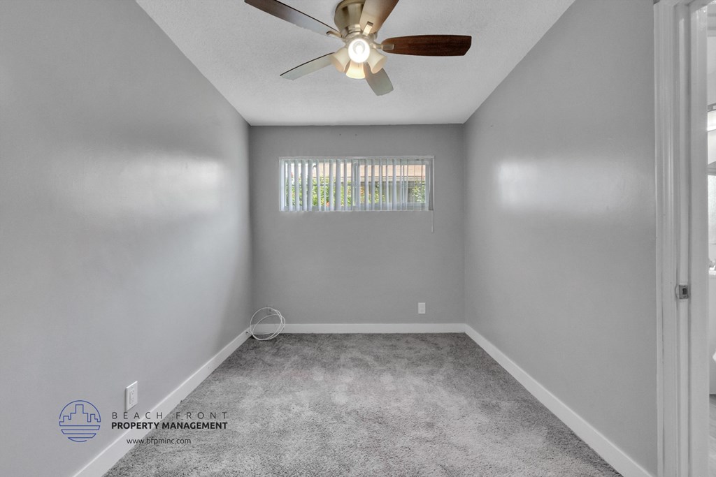 a bedroom with gray walls and a ceiling fan