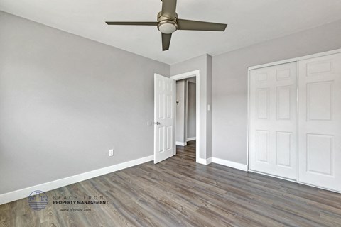 the living room of a house with grey walls and a ceiling fan
