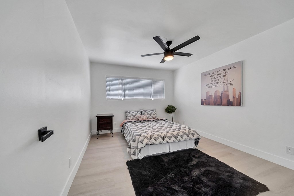 a bedroom with a bed and a ceiling fan