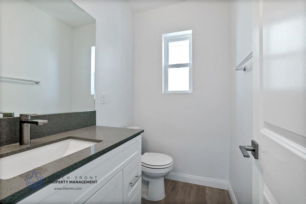 a bathroom with a sink toilet and a window