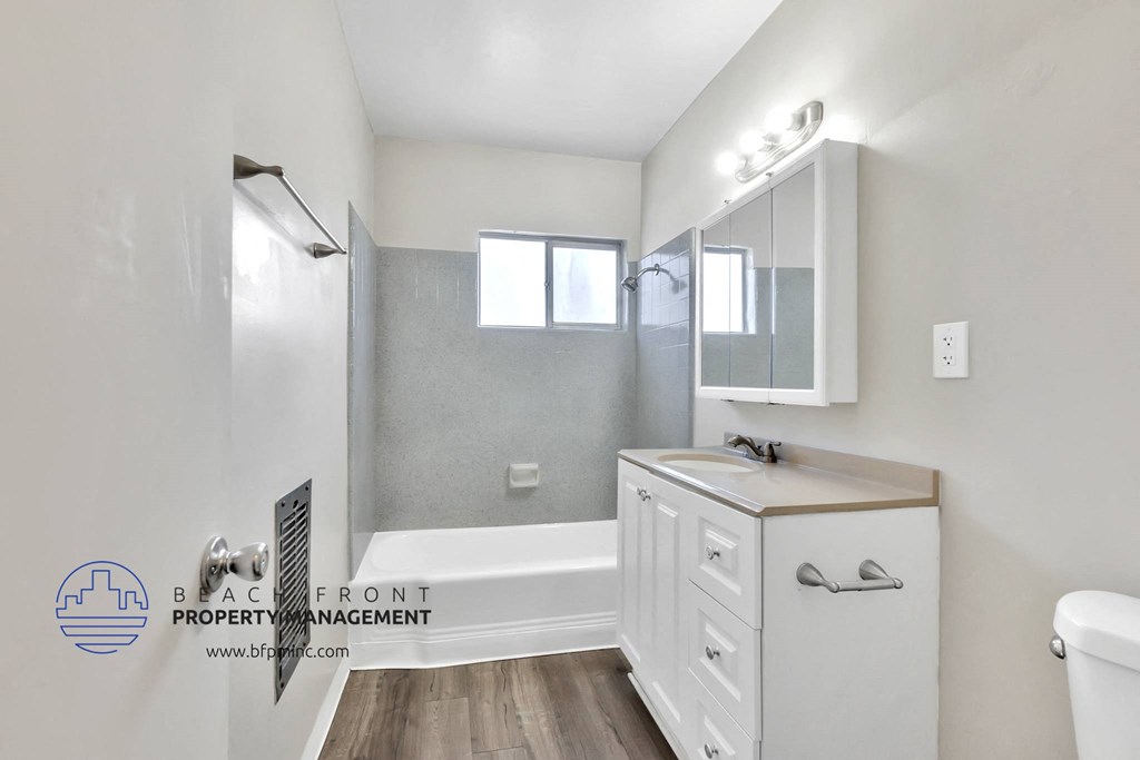 a bathroom with a white vanity and a shower and a sink