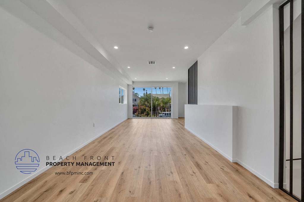 a renovated living room with white walls and wood floors