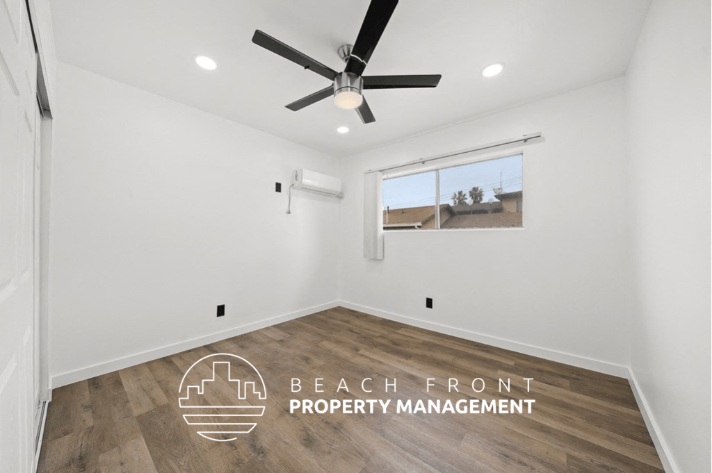 a room with white walls and a ceiling fan and a window