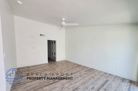 an empty room with white walls and a ceiling fan