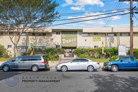 a parking lot in front of a building with cars parked in front