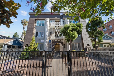an apartment building with a fence and a gate in front of it