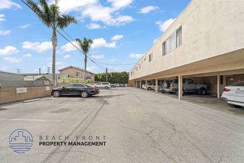 A parking lot with cars and a building with the logo