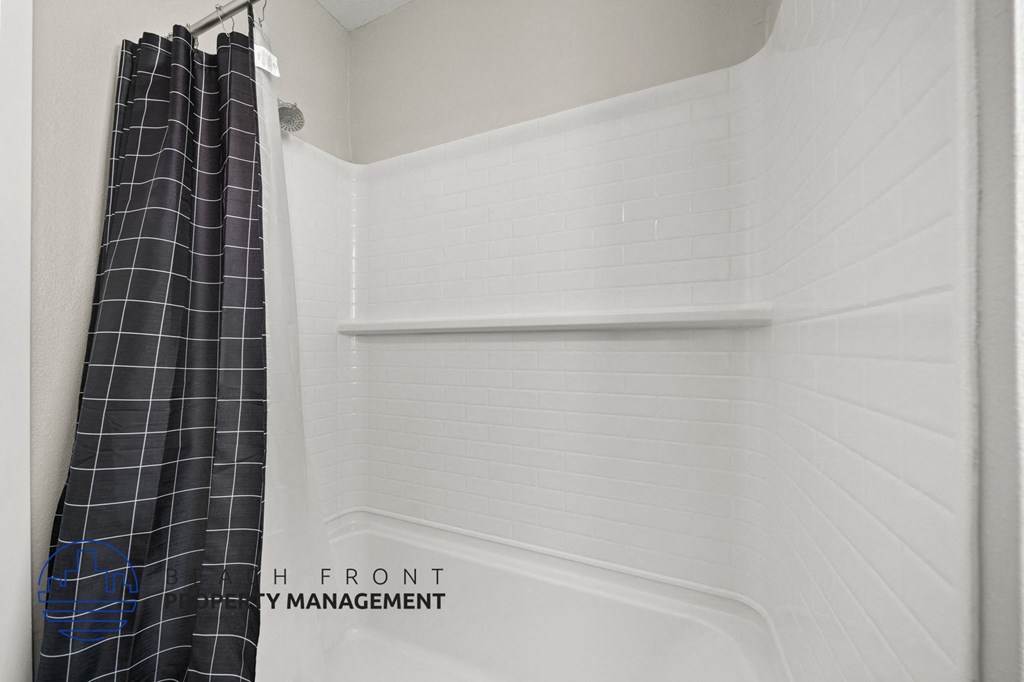 A white bathroom with a shower curtain and a sign that says "Front".