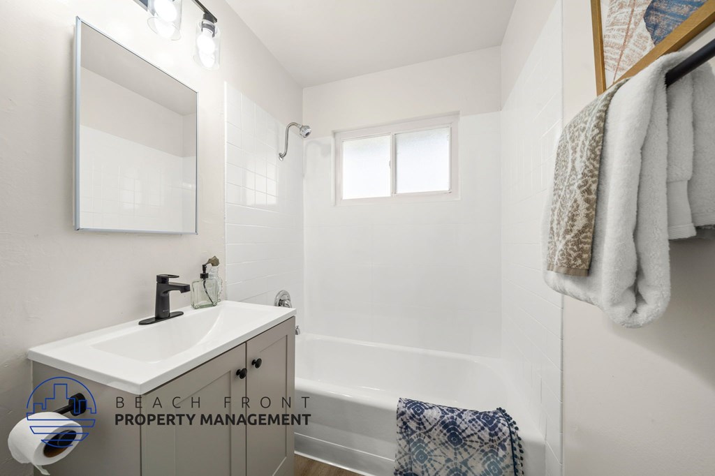 A bathroom with a white sink and a mirror.