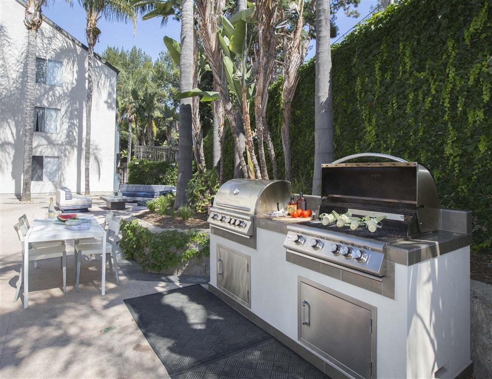a barbecue grill in a backyard next to a table