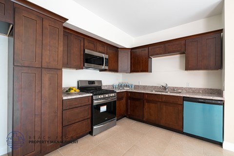 A kitchen with brown cabinets and a blue dishwasher.
